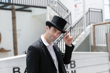 Man wearing a black Gemvie top hat with a dark jacket outdoors